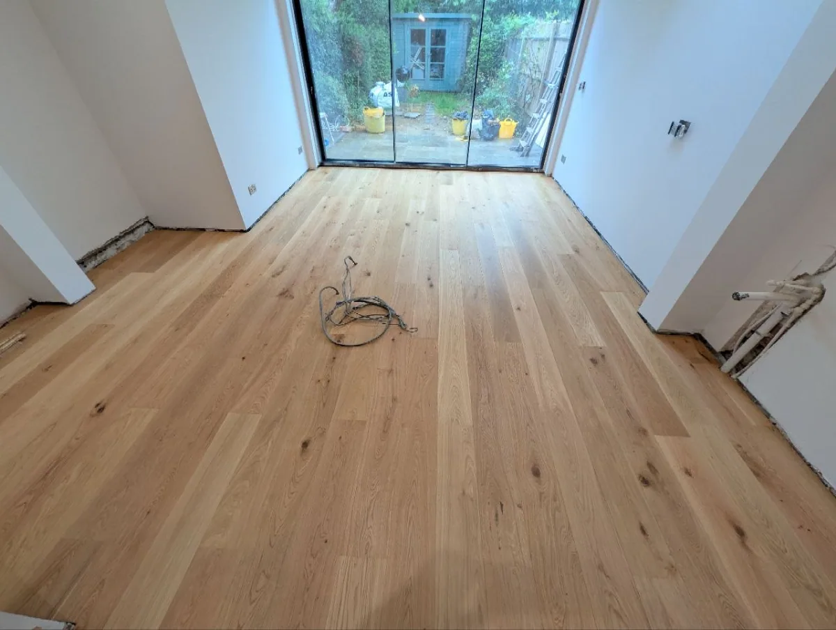 Wide oak floorboards running towards the glazed garden wall of a Dulwich extension