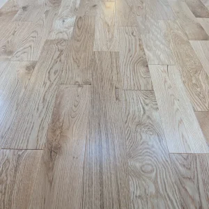 Close view of the lacquered natural oak surface, showing knots and random lengths