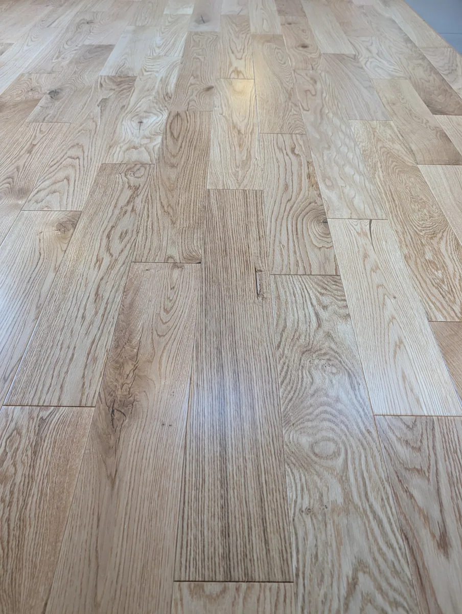 Close view of the lacquered natural oak surface, showing knots and random lengths