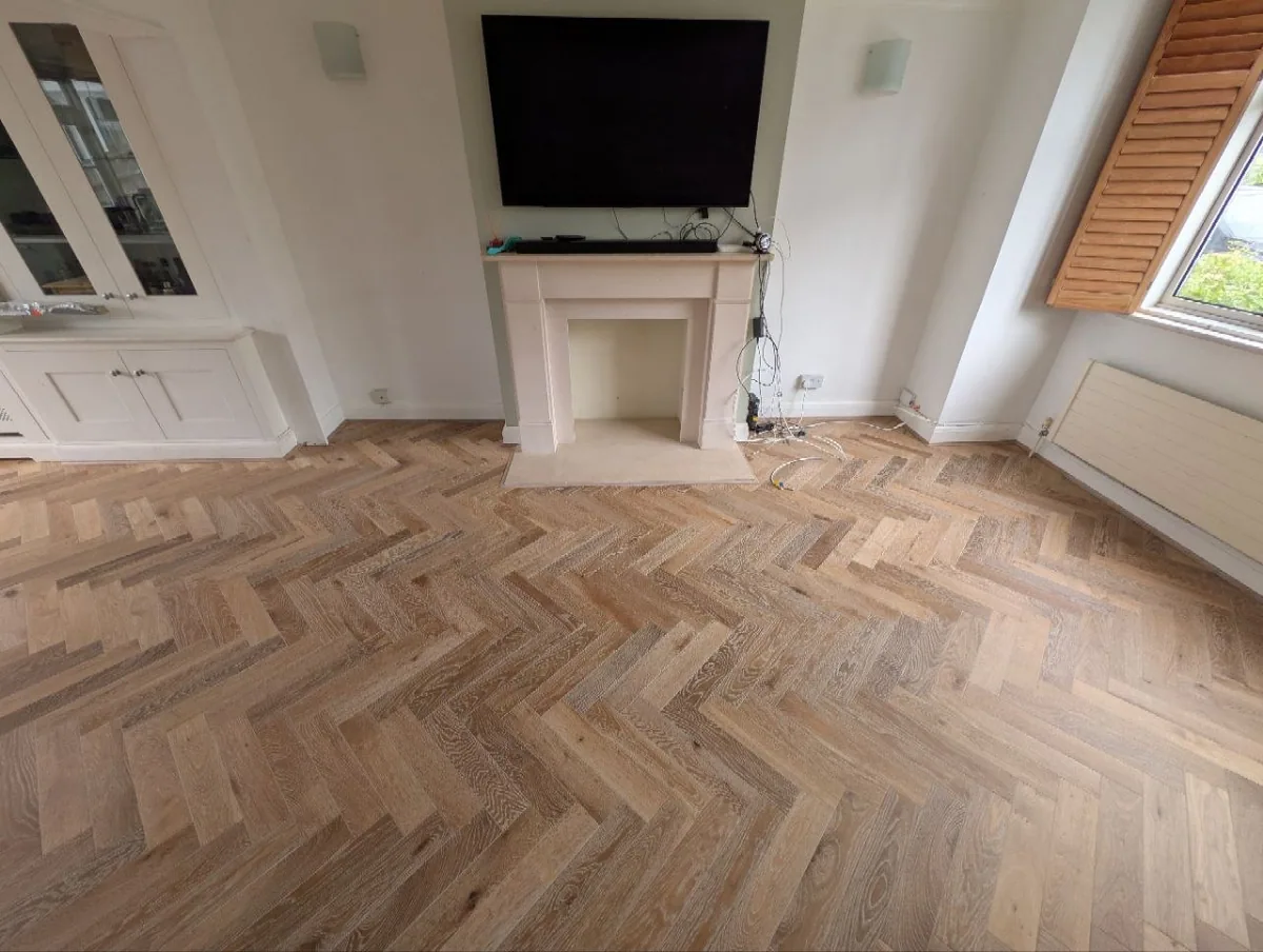 Smoked oak herringbone floor in a Norwood living room with a stone fireplace