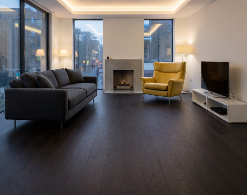 Dark espresso oak engineered wood flooring in modern London living room, orange armchair
